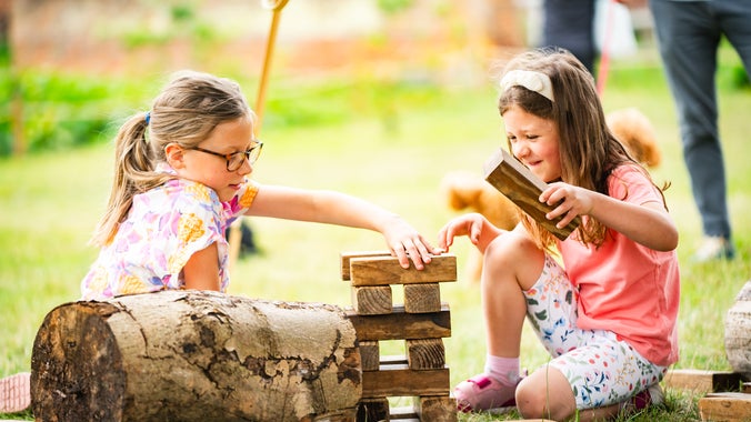 Two girls play Jenga together in the Walled Garden at Ickworth